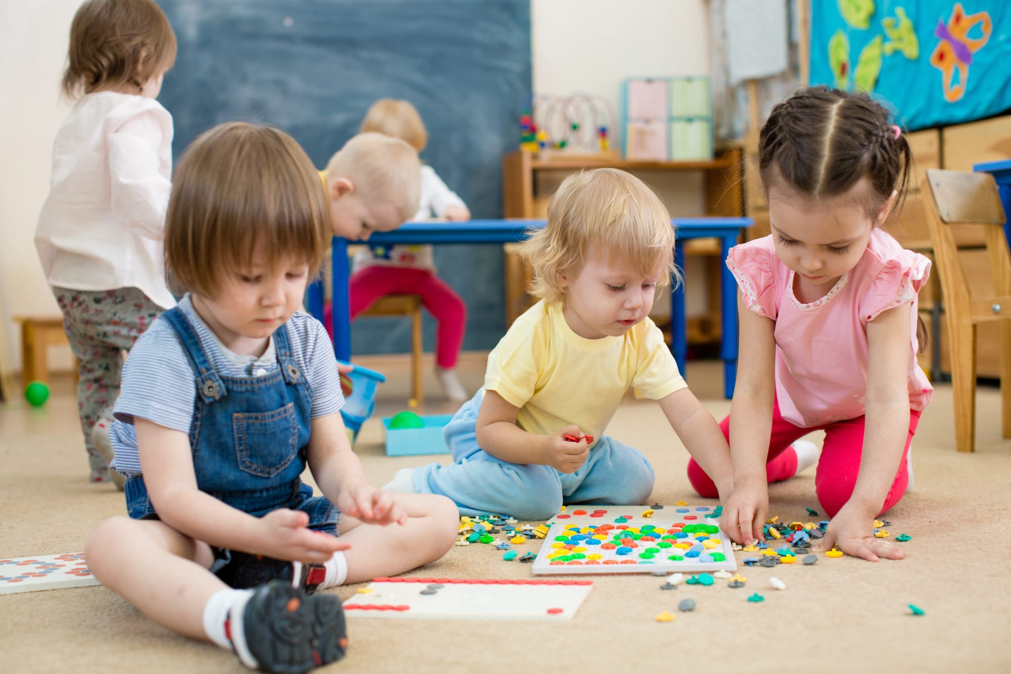 kids or children playing mosaic game in kindergarten room daycare business plan