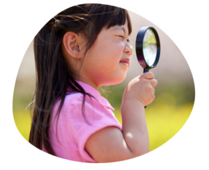 Child using a magnifying glass to represent reviewing the childcare market before changing tuition