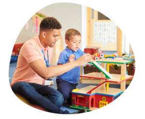 Teacher working with a child to represent childcare staffing costs and tuition planning